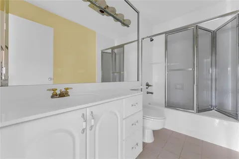 a bathroom with a double vanity sink toilet and shower