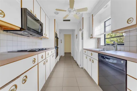 a large kitchen with stainless steel appliances granite countertop a sink and dishwasher a stove top oven with wooden floor