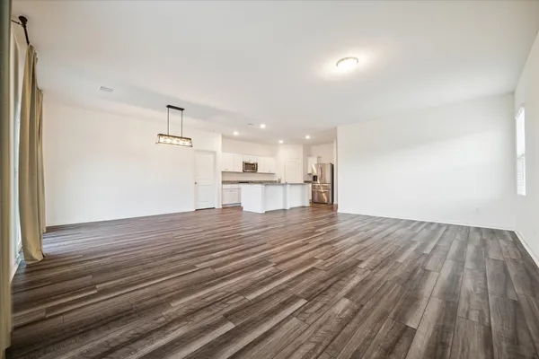 a view of a kitchen with wooden floor and windows