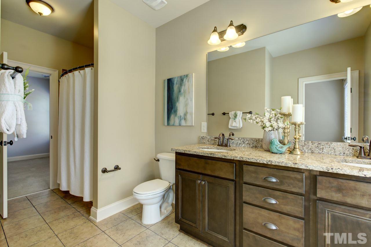 226 Penley Circle Raleigh, NC 27609 - Photo 14 of 14 a bathroom with a granite countertop sink a toilet and a mirror