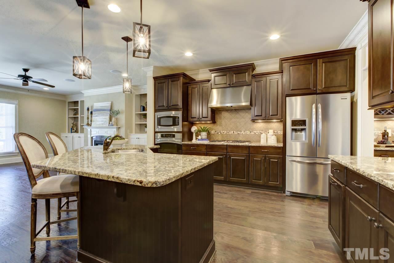 226 Penley Circle Raleigh, NC 27609 - Photo 3 of 14 a kitchen with stainless steel appliances granite countertop a sink a stove a refrigerator cabinets and chairs