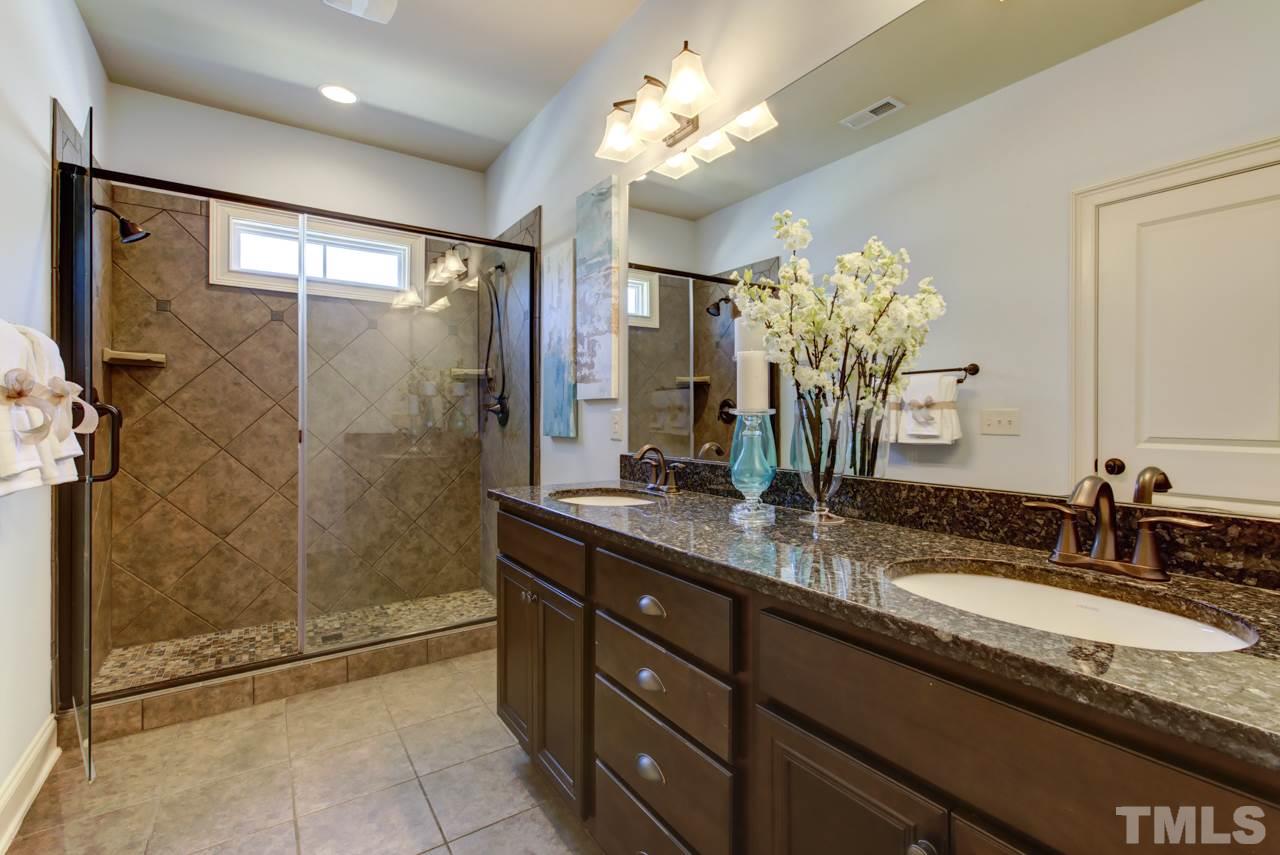226 Penley Circle Raleigh, NC 27609 - Photo 10 of 14 a bathroom with a granite countertop sink a mirror and a shower