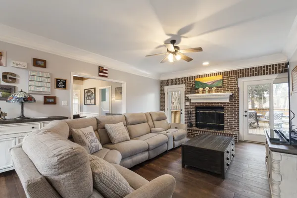 a living room with furniture a fireplace and wooden floor