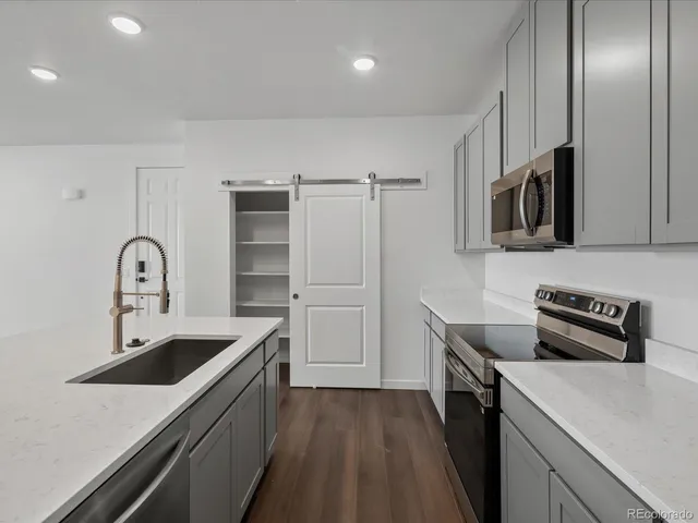 a kitchen with stainless steel appliances a sink a stove and cabinets