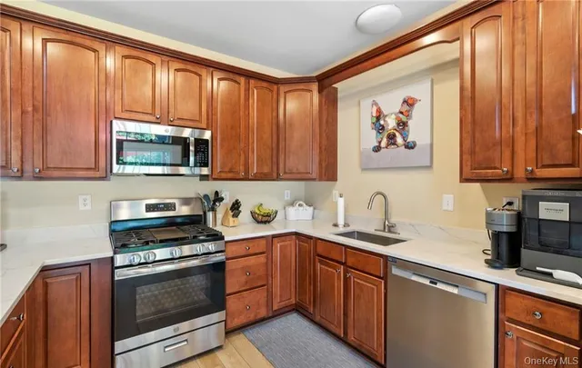 a kitchen with stainless steel appliances granite countertop a stove a sink dishwasher and a microwave