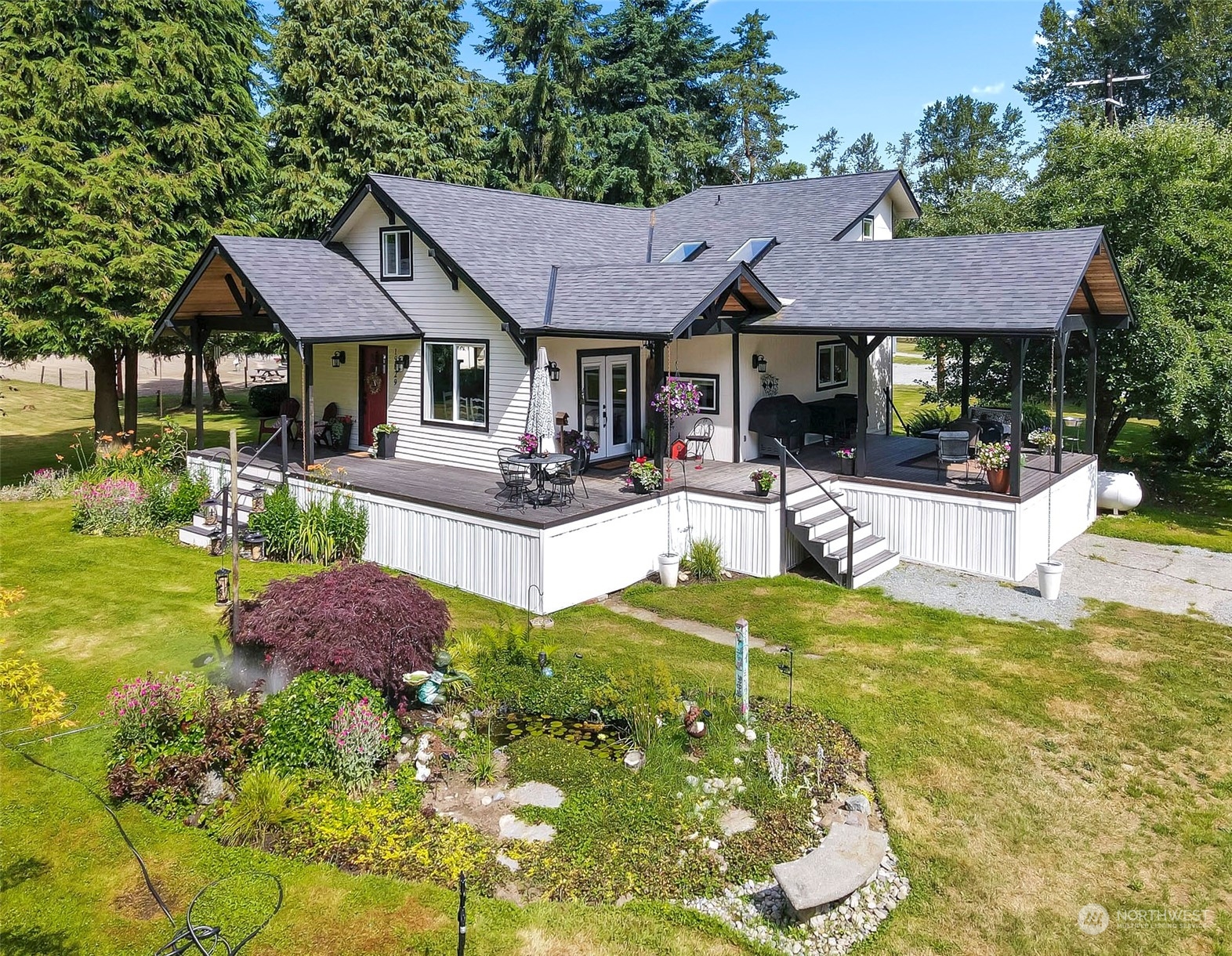 a view of house with garden and outdoor seating