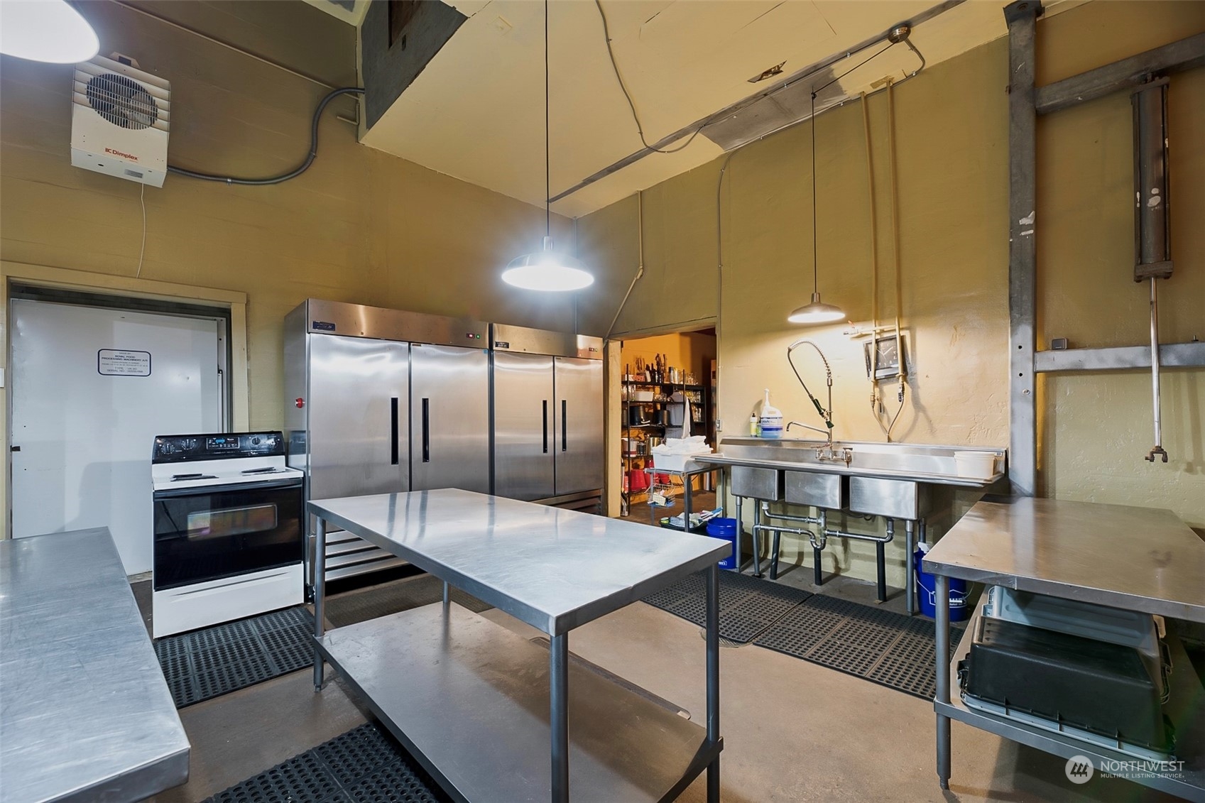 19829 Niederle Road Monroe, WA 98272 - Photo 30 of 39 a kitchen with stainless steel appliances kitchen island granite countertop a table chairs stove and refrigerator