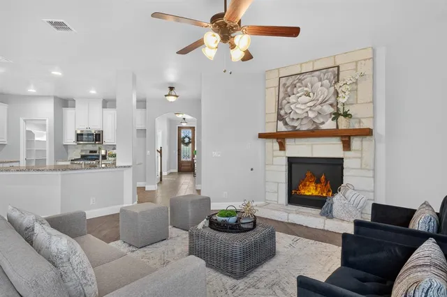 a living room with furniture a fireplace and a large window