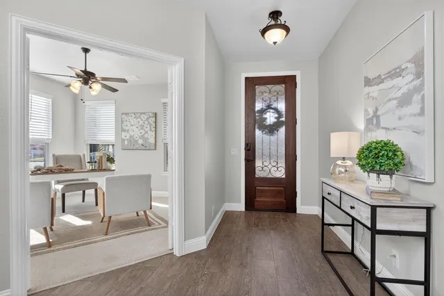 a view of a livingroom with furniture a chandelier fan and windows