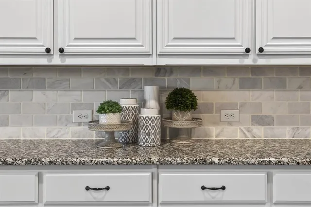 a large kitchen with cabinets chairs and wooden floor
