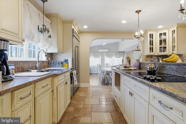 a kitchen that has a lot of white cabinets and stainless steel appliances