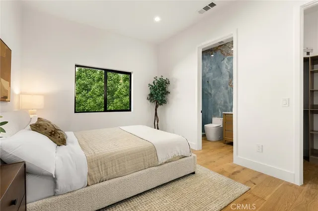 a view of a kitchen with white cabinets and wooden floor