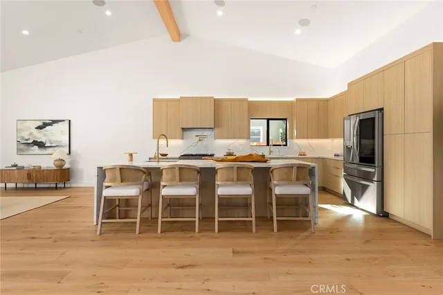 a living room with furniture a large window and wooden floor