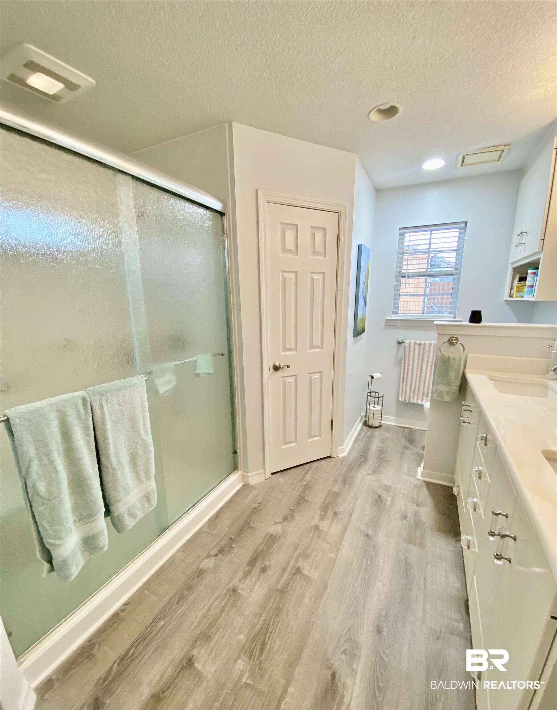 2872 Avenida Alberto Lillian, AL 36549 - Photo 20 of 31 Bathroom featuring hardwood / wood-style floors, vanity, a shower with shower door, and a textured ceiling