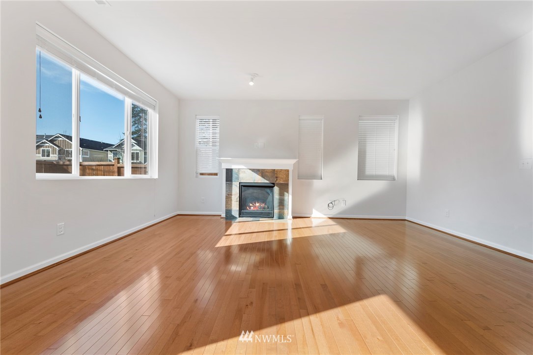 3910 177th Street Southeast Bothell, WA 98012 - Photo 4 of 27 a view of an empty room with wooden floor fireplace and a window