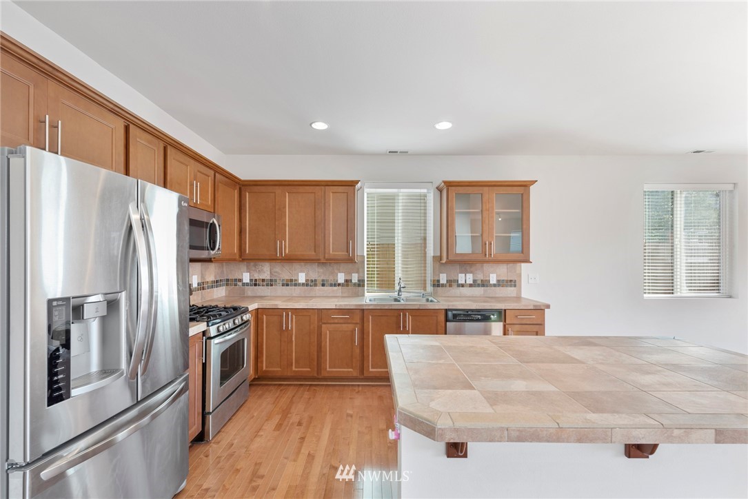 3910 177th Street Southeast Bothell, WA 98012 - Photo 7 of 27 a kitchen with stainless steel appliances granite countertop a refrigerator a stove and a sink