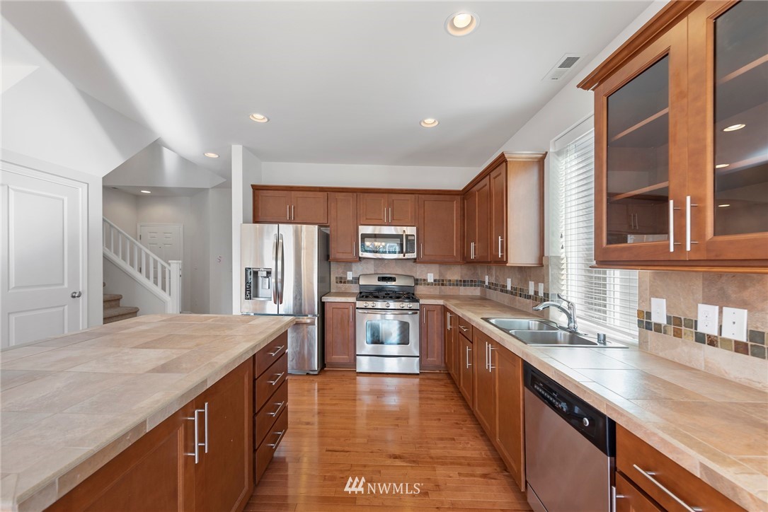 3910 177th Street Southeast Bothell, WA 98012 - Photo 8 of 27 a kitchen with stainless steel appliances granite countertop sink stove refrigerator and cabinets