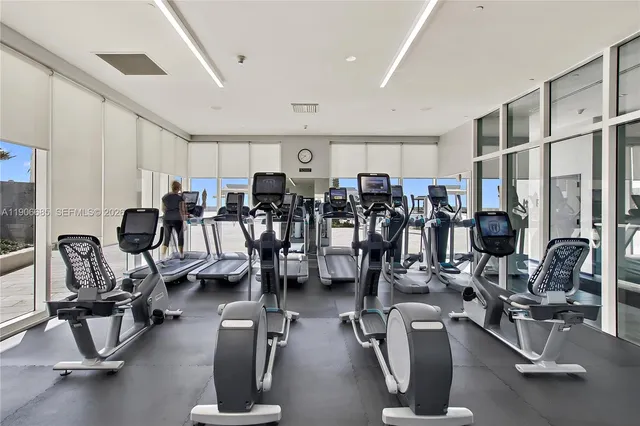 a living room with couches and kitchen view with wooden floor