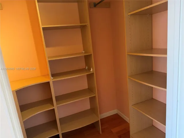 a view of walk in closet with empty racks