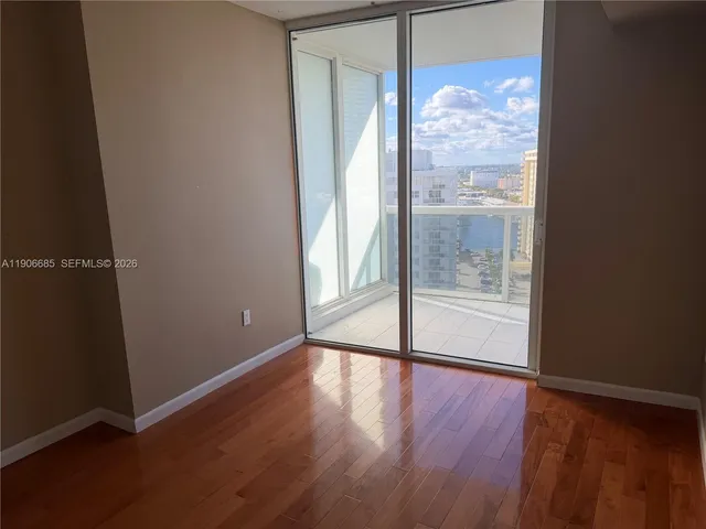 an empty room with wooden floor and door