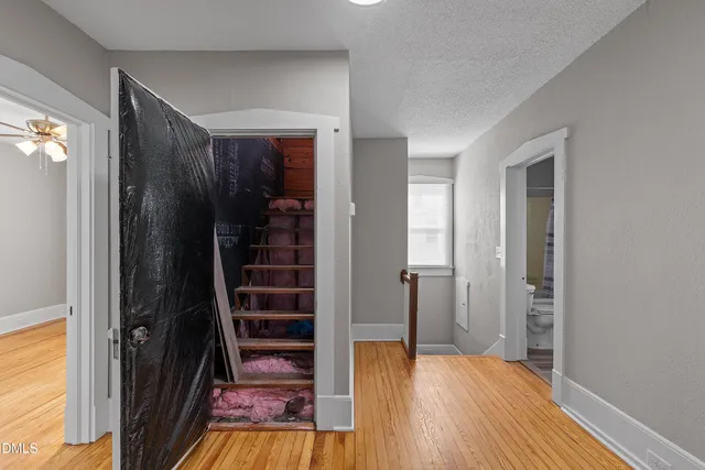 a view of a hallway with wooden floor and closet