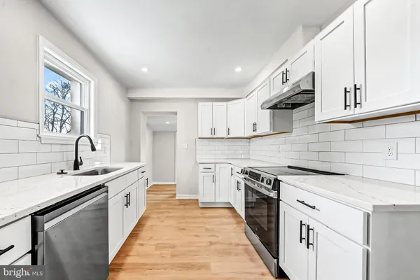 a kitchen with a sink stove and cabinets