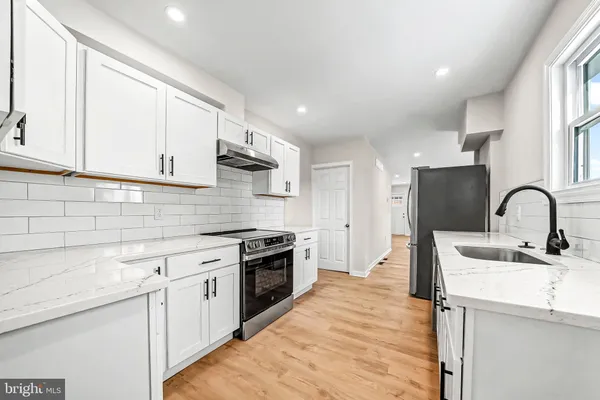 a kitchen with white cabinets appliances and sink
