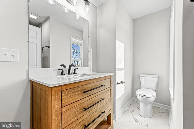 a bathroom with a toilet sink and mirror