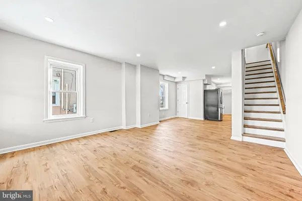 a view of empty room with wooden floor and entryway