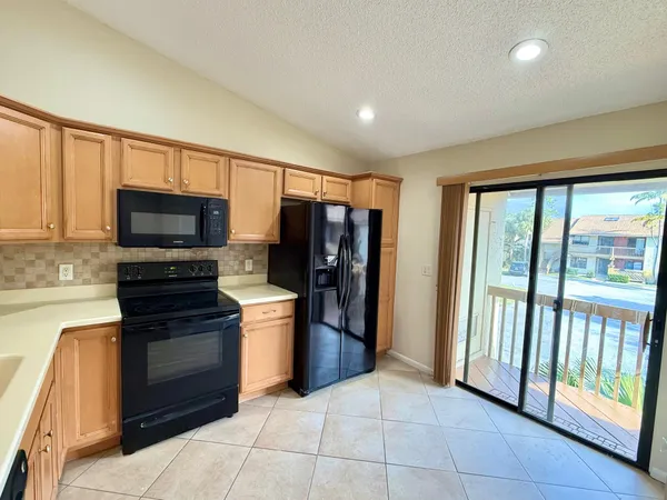 a kitchen with stainless steel appliances granite countertop a refrigerator and a stove top oven