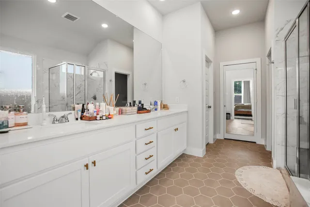 a bathroom with a double vanity sink mirror and bathtub