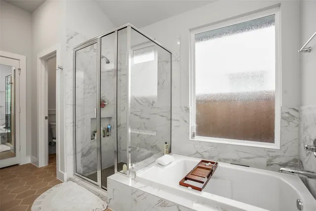a bathroom with a tub a sink and a large mirror