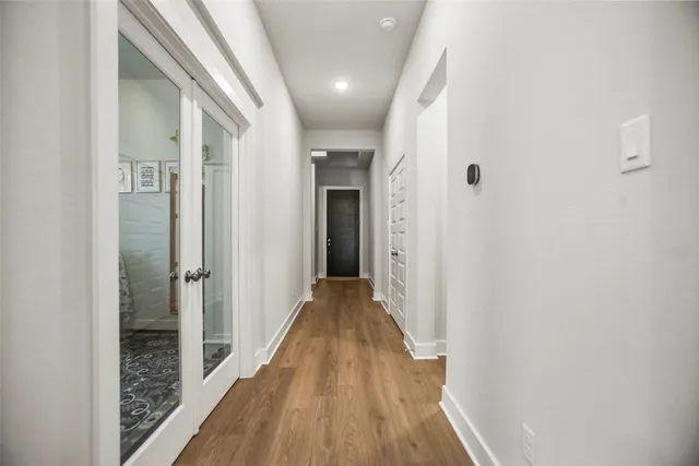 a view of a hallway with wooden floor and staircase