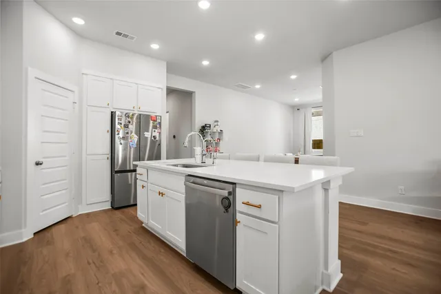 a kitchen with stainless steel appliances granite countertop a sink and a refrigerator