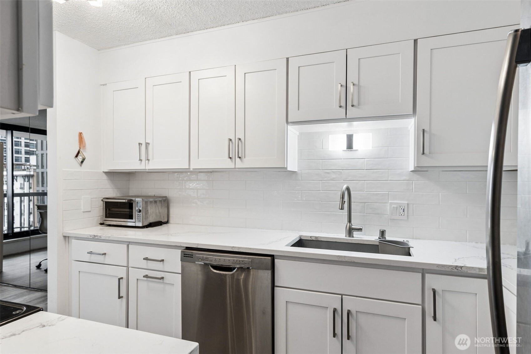 2100 3rd Avenue, Unit 802 Seattle, WA 98121 - Photo 9 of 35 a kitchen with white cabinets and white appliances