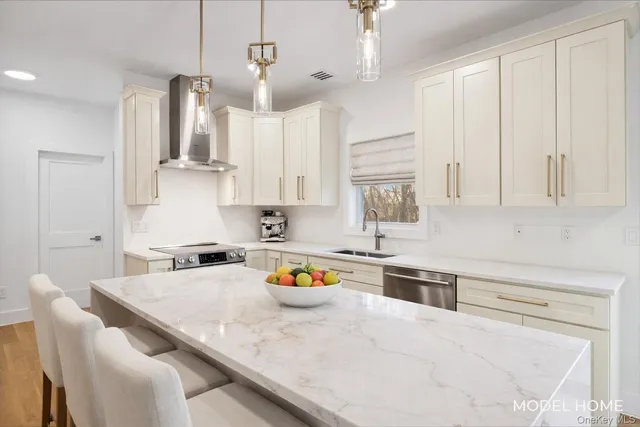 a kitchen with stainless steel appliances granite countertop a sink a stove and white cabinets
