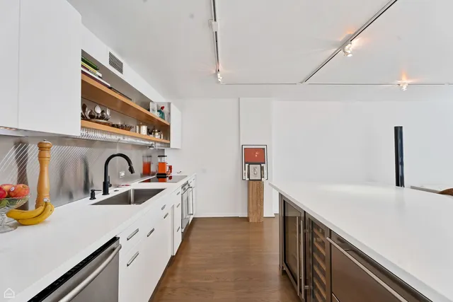 a kitchen with stainless steel appliances granite countertop a sink and a refrigerator