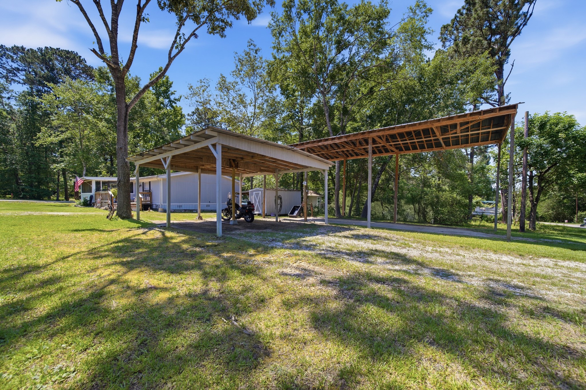 199 Apple Tree Livingston, TX 77351 - Photo 15 of 41 View of the carports. The smaller one covers at least 2 vehicles. The larger one is for an RV and comes complete with electric, water and sewer.