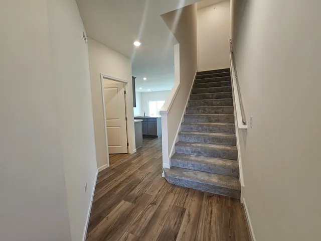 a view of a hallway with wooden floor and entryway