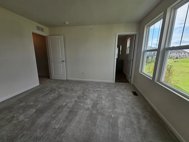 an empty room with windows and closet