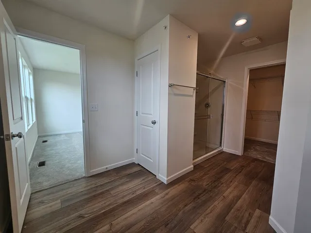 an empty room with wooden floor and entrance