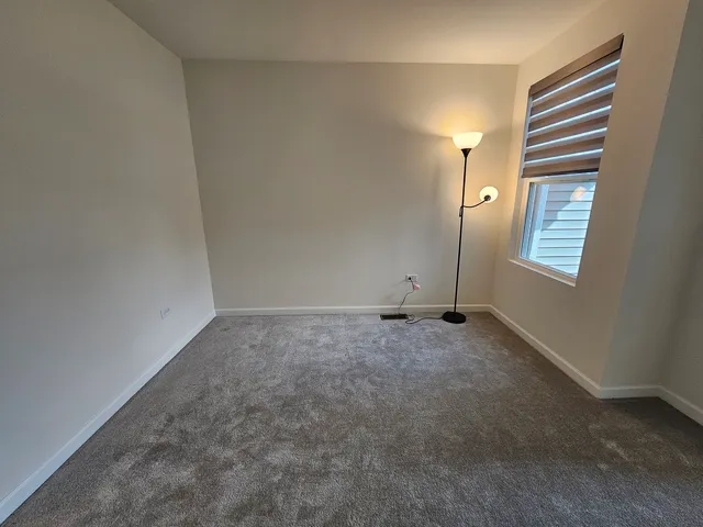 an empty room with windows and fireplace