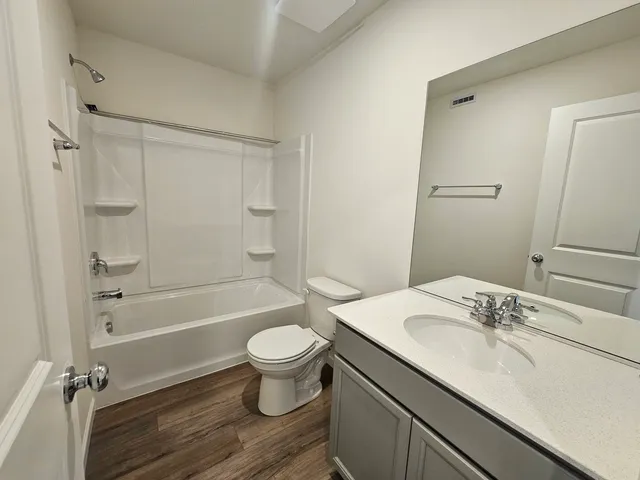 a bathroom with a granite countertop sink toilet a mirror and shower