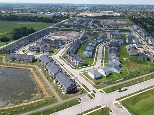 an aerial view of residential houses with outdoor space and river
