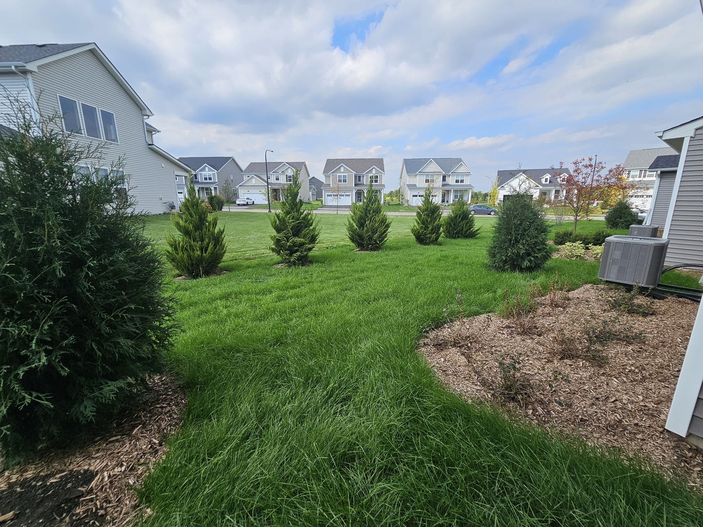 5954 Hawkweed Drive, Unit 5954 Plainfield, IL 60585 - Photo 32 of 35 a view of a garden with a building in the background