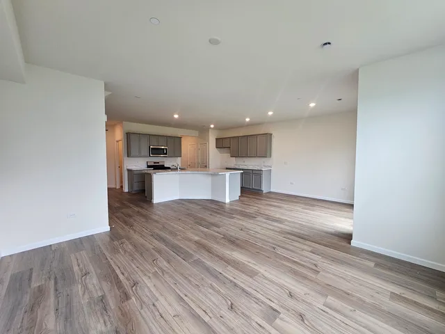a view of kitchen with wooden floor and electronic appliances