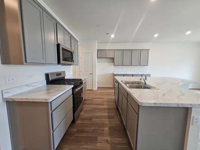 a kitchen with a sink stove top oven and wooden cabinets