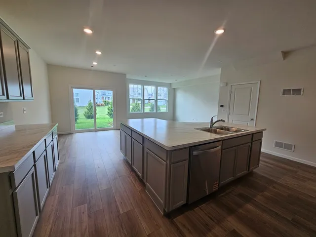 a kitchen with kitchen island wooden floors and sink