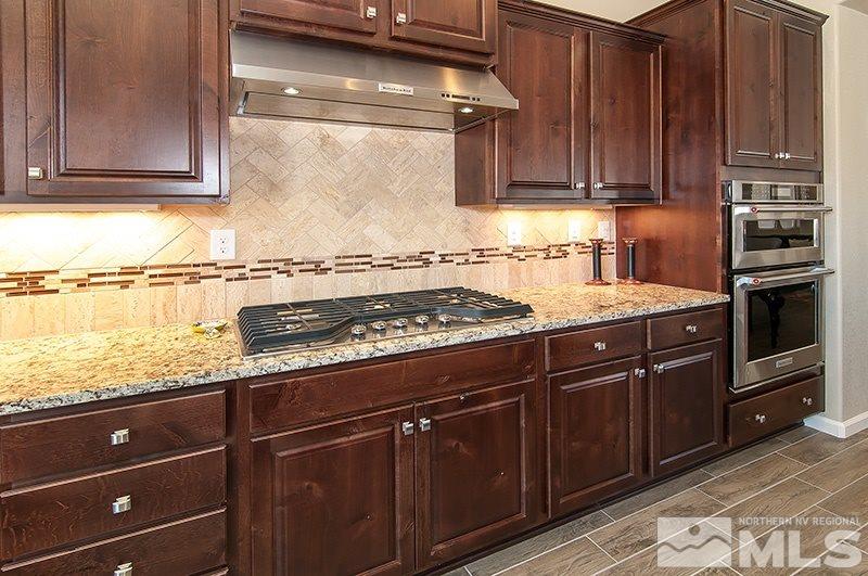 9775 Hafflinger Lane Reno, NV 89521 - Photo 7 of 25 a kitchen with granite countertop a stove and cabinets