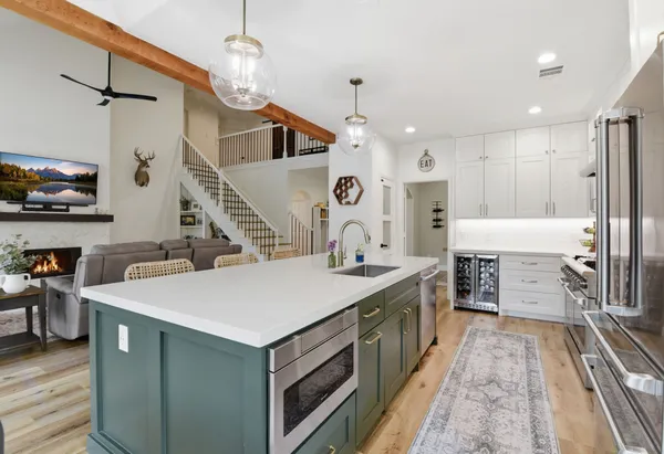 a large kitchen with kitchen island a sink appliances and a counter top space
